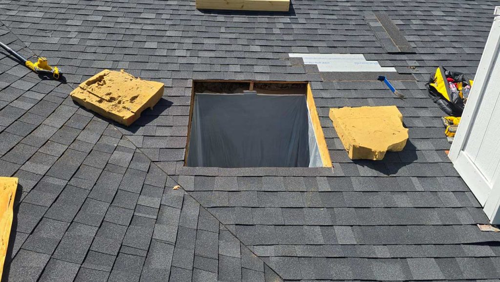 A roof featuring a newly cut hole for a skylight installation.